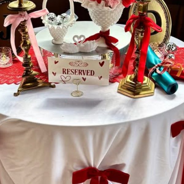Red and white reserved table with ribbon-tied candlesticks